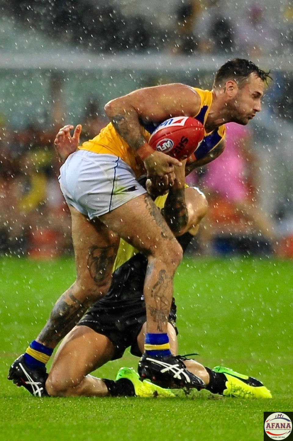 Chris Masten is caught by a sliding Brandon Ellis in extremely wet conditions