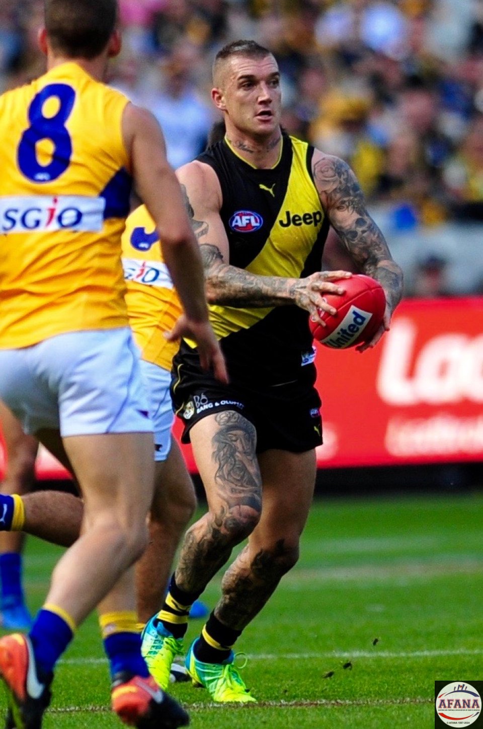 Dustin Martin setting for a the long kick as Jack Redden (8) prepares to tackle